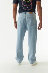 Jean de corte baggy con tiro medio, diseño amplio en piernas y cadera, con cierre y botón frontal.