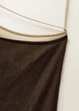 Vestido midi de punto fino en tejido de lyocell, con diseño entallado y cuello asimétrico. Presenta un diseño combinado en dos tonos, con tirantes finos y cierre de lazo.