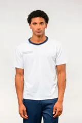 Remera de manga corta Umbro color blanco, con cuello redondo en tono azul oscuro y el logo de la marca bordado en el pecho.