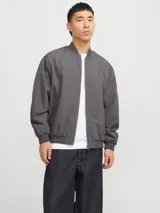 Campera bomber liviana color gris oscuro, con cierre frontal de cremallera, cuello baseball, bolsillos funcionales y puños elásticos acanalados.