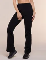Legging deportiva negra de tiro alto, confeccionada en tejido de alta densidad, con ajuste entallado en los muslos y diseño acampanado desde la rodilla hacia el ruedo. Cuenta con una pretina ancha lisa que brinda soporte y contención abdominal.
