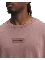 Remera de corte oversize con cuello redondo acanalado y hombros caídos. Presenta un acabado de efecto lavado y un parche rectangular en el pecho con el logo y la inscripción Project Rock.
