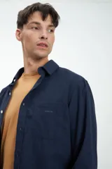 Camisa de manga larga azul confeccionada en tela 100% algodón. Bolsillo en pecho y botones personalizados. Calce clásico. Tela simil paño.