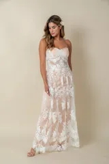 Vestido largo de tul bordado con encaje y perlas sobre viso color champagne, de corte recto y escote palabra de honor.