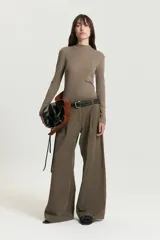 Pantalón pinzado color marrón de corte sastrero, confeccionado en tencel con elastano. Presenta pinzas en el delantero, bolsillos delanteros americanos y bolsillos ojal traseros.