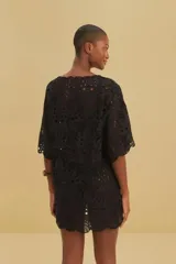 Vestido túnica corto negro de algodón con bordados calados, escote en V y mangas cortas holgadas.
