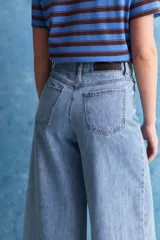 Jean wide leg de tiro alto con calce amplio y pierna ancha, de color celeste con lavado clásico. Presenta diseño de cinco bolsillos y cierre frontal con botón y cremallera.