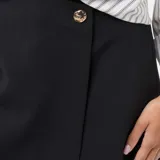 Falda pantalón de color negro con diseño asimétrico y cierre frontal con botón dorado decorativo.