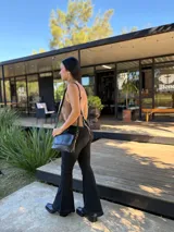 Bota corta de cuero negro con punta cuadrada y taco bloque de altura media con textura grabada. Presenta un diseño minimalista con costura central vertical y cierre lateral interno.