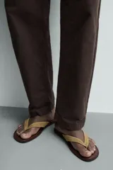 Sandalias planas de cuero para hombre, con suela marrón oscuro y tiras anchas en el empeine de ante en color tostado.