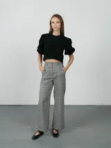 Pantalón de vestir de corte recto y tiro alto, con estampado de cuadros tipo príncipe de gales en tonos grises. Cuenta con bolsillos laterales y cierre frontal.