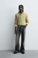 Polo de punto con diseño desagujado, color verde, de corte relajado, manga larga y cuello solapa con cierre frontal de tres botones. Presenta puños y ruedo con acabado en rib.