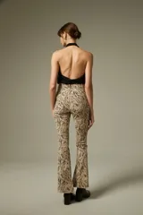 Pantalon de jean con corte flare y tiro alto, estampado con diseño animal print de leopardo en tonos marrones. Cuenta con bolsillos funcionales y ruedo desflecado.