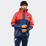 Campera de lluvia Umbro del Club Nacional de Football, con diseño de bloques de color blanco y azul marino. Presenta capucha, cierre frontal completo, puños elásticos y detalles de piping en color rojo. Incluye logo de la marca y escudo del club en el pecho.