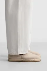 Alpargatas color beige confeccionadas en tejido de lino y algodón, con tirador trasero y suela recubierta de yute.