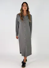 Vestido camisero midi de corte recto y holgado, con cierre frontal de botones, cuello camisero, mangas largas con puños abotonados y bolsillos frontales superiores con solapa.