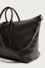 Bolso shopper de hombro fabricado en piel con acabado abatanado. Cuenta con compartimento principal con cierre de cremallera, interior con bolsillo plano y bolsillo con cierre. Incluye dos asas de mano, asa de hombro y detalle de llavero colgante.