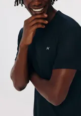 Camiseta deportiva de manga corta y cuello redondo en color negro, con pequeño logo impreso en el pecho.
