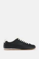 Championes de estilo running confeccionados en piel con textura granulada. Presentan detalles en contraste de color en el talón, cordones y lengüeta, con suela dentada de goma.