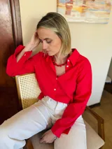 Camisa de manga larga color rojo ciruela, con cuello clásico y cierre frontal de botones de nácar.