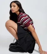 Short pollera de estilo sastre en color negro, con diseño de pliegues estructurados, cintura con trabillas y cinturón ajustable incluido.