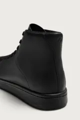 Zapatilla deportiva tipo botín para hombre, confeccionada en piel lisa de color negro, con detalles de pespuntes, cordones al tono y suela plana.