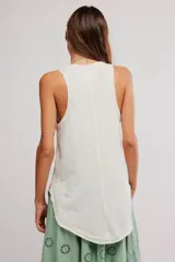 Musculosa blanca de algodón con acabado burnout, diseño sin mangas, espalda nadadora y estampa gráfica frontal con motivos florales y texto.