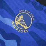 Musculosa de básquet azul con estampado camuflado, logo de la NBA en el hombro y diseño con el puente Golden Gate y el nombre del equipo.