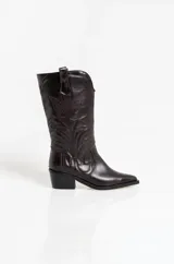 Bota texana de caña media confeccionada en cuero vacuno color marrón oscuro. Presenta un diseño clásico con costuras decorativas en el frente y puntera ligeramente afinada, con un taco bajo y estable.