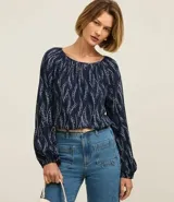 Blusa azul marino con estampa de ramos en color blanco, escote canoa, mangas largas con elástico en los puños y corte holgado.