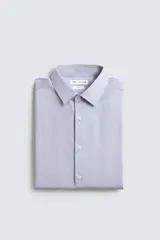 Camisa de algodón de manga larga, color celeste claro, con cuello italiano y cierre frontal de botonadura.