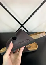 Sandalias de tiras de ecocuero marrón con dos hebillas metálicas ajustables y plantilla anatómica.