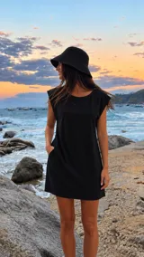 Vestido corto negro sin mangas, con escote redondo, hombros estructurados y bolsillos laterales.