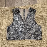 Chaleco de cuero con acabado metalizado plateado, diseño sin mangas, escote en V y corte recto.