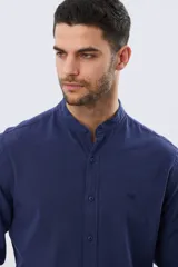 Camisa de lino y algodón color blanco, con cuello mao, manga larga y cierre frontal de botones. Presenta un pequeño logo bordado en el pecho.