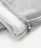 Pantalón de corte baggy confeccionado en algodón con felpa, color gris melange. Presenta cintura elástica con cordón ajustable, bolsillos laterales y bajo con regulador elástico.
