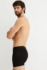 Pack de tres calzoncillos tipo trunk (boxer ajustado a media pierna) con cintura elástica. Incluye uno verde oscuro, uno gris jaspeado y uno negro.