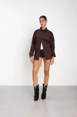 Botas texanas de cuero negro con diseño de caña arrugada y puntera fina. Presentan un taco cuadrado de altura media y tiradores laterales en la parte superior de la caña.