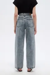 Pantalón jean de tiro alto y corte ancho, con diseño estampado de pedrería y tachas en la parte frontal.