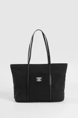 Cartera tipo shopper color beige con asas y detalles decorativos en cuero sintético negro. Cuenta con un bolsillo frontal exterior adornado con una etiqueta rectangular de la marca Symphorine.