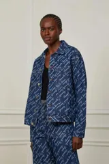 Campera de jean azul con estampado de logomanía en blanco. Corte recto, cuello clásico, cierre con botones metálicos y bolsillos delanteros. Marca Animale Jeans.