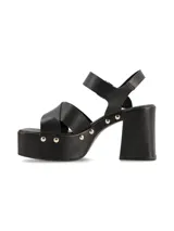 Sandalia de plataforma color negro, con taco ancho, tiras cruzadas en el empeine y tira al tobillo con hebilla ajustable. Cuenta con detalles de tachas metálicas en los laterales de la plataforma y el talón.