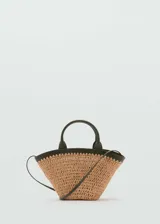 Bolso de mano tipo cesta con cuerpo de fibras naturales trenzadas y detalles en cuero sintético color verde oliva. Cuenta con dos asas cortas, una correa bandolera ajustable y cierre de botón magnético.