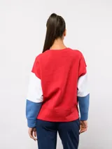 Buzo de cuello redondo con diseño de bloques de color en rojo, blanco y azul. Presenta el logo de Umbro y el escudo del Club Nacional de Football bordados en el pecho.