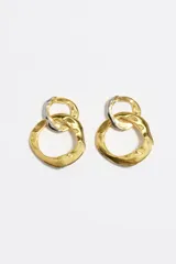 Caravanas de diseño bicolor con textura orgánica, compuestas por dos aros entrelazados de diferentes tamaños. Presentan un acabado metálico en tonos dorado y plateado.