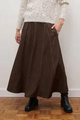 Falda larga de jean color azul oscuro con corte evasé y costuras con pespuntes a contratono. Presenta una cintura elástica para mayor comodidad.