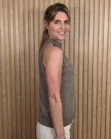 Musculosa tejida de punto con hilo lurex color beige, cuello alto y diseño halter sin mangas.