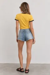 Short de jean estilo vintage, de tiro bajo con efecto desgastado, detalles rotos y cinturón incorporado con hebilla metálica.