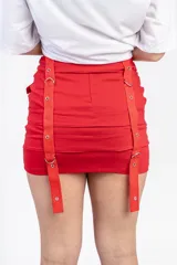 Minifalda negra con tres hileras de correas ajustables con hebillas plateadas.