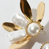 Par de caravanas con forma de flor, con pétalos dorados y perlas blancas.